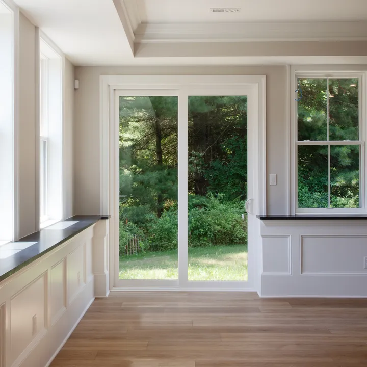 OKNA Elegante 8800 sliding patio door opening to a wooded yard