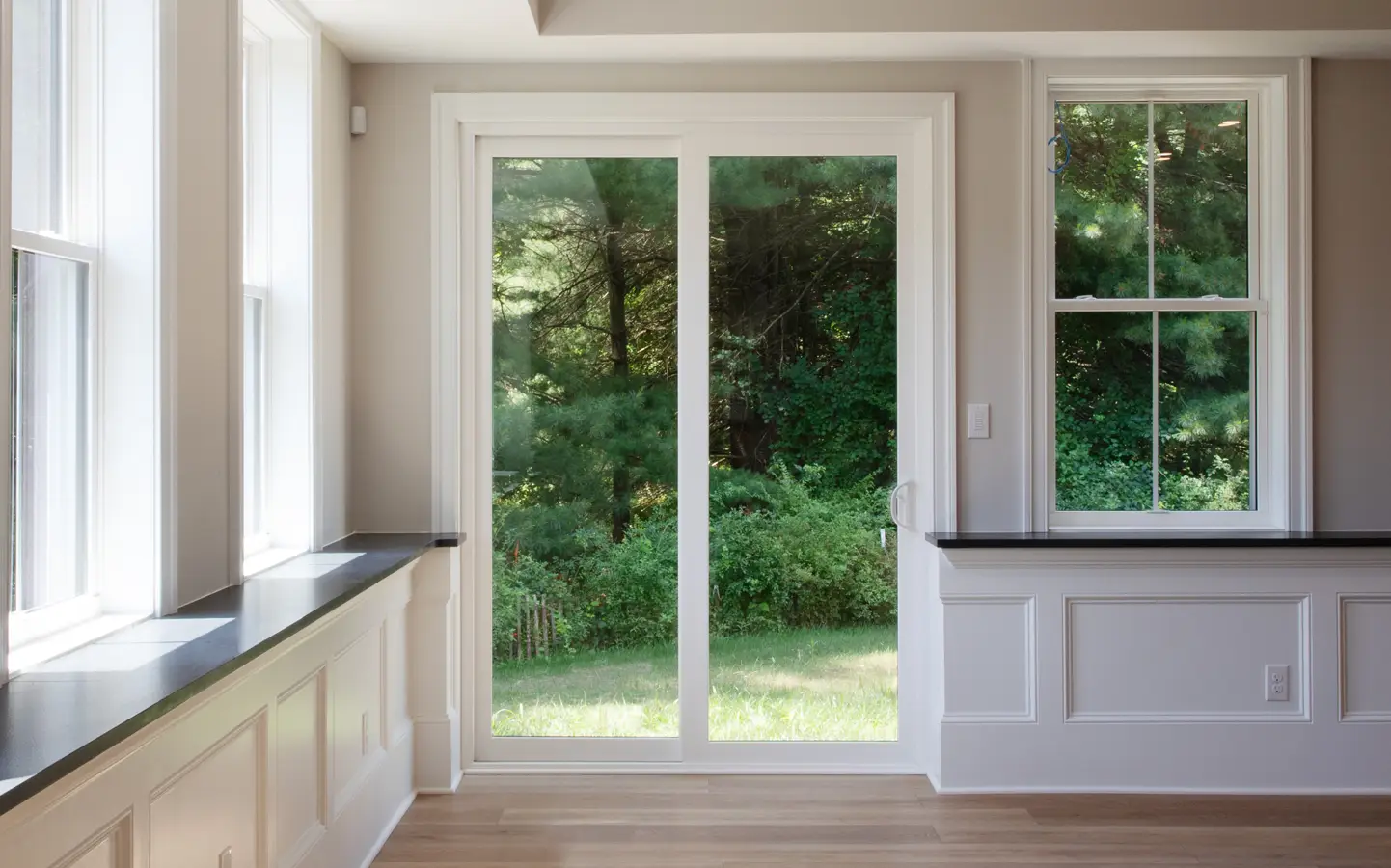 OKNA Elegante patio door and double hung windows in a bright room