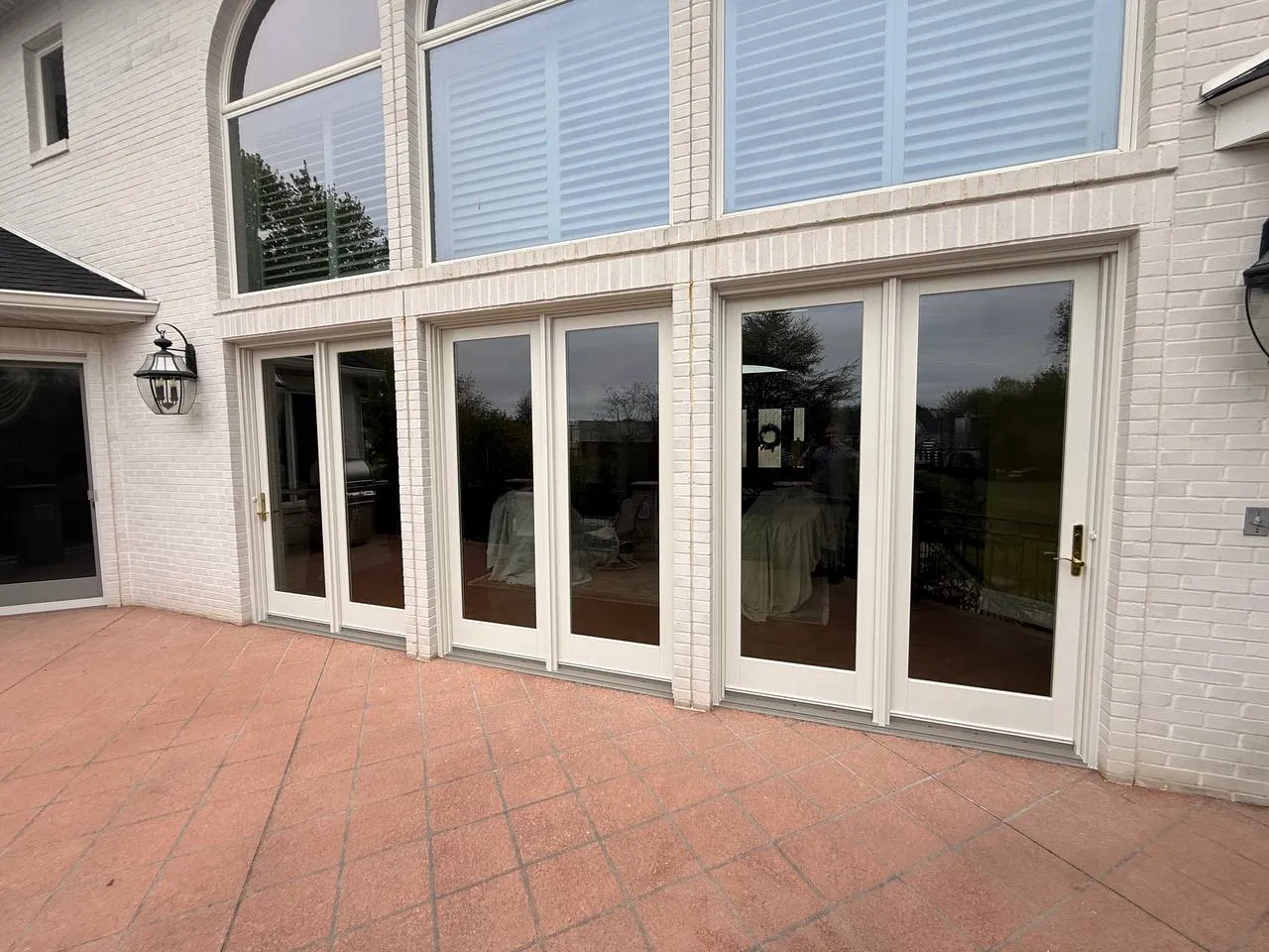 Andersen French patio doors: Three-door run onto a brick patio. Installed by HomeTrust Windows & Doors.