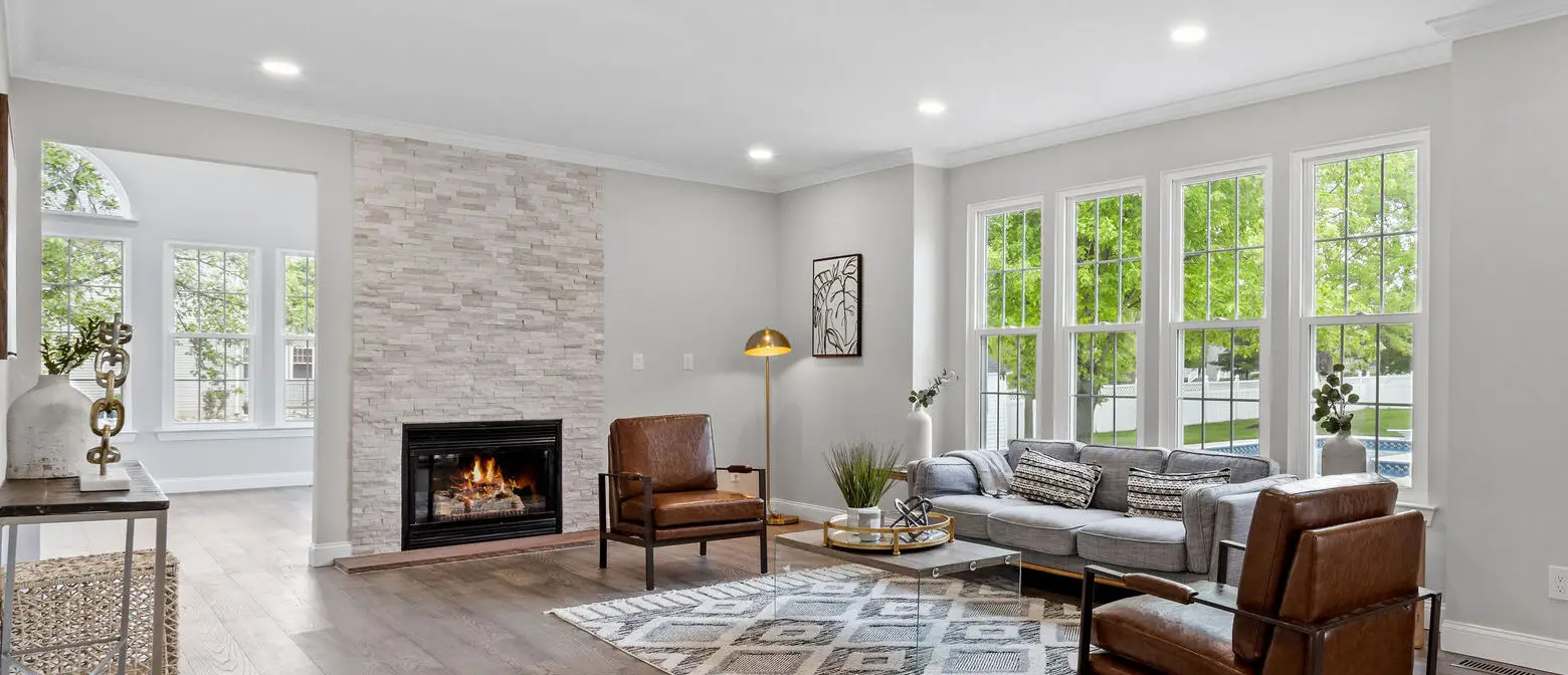 Living room with new light-filled windows, fireplace and couch after a HomeTrust window replacement