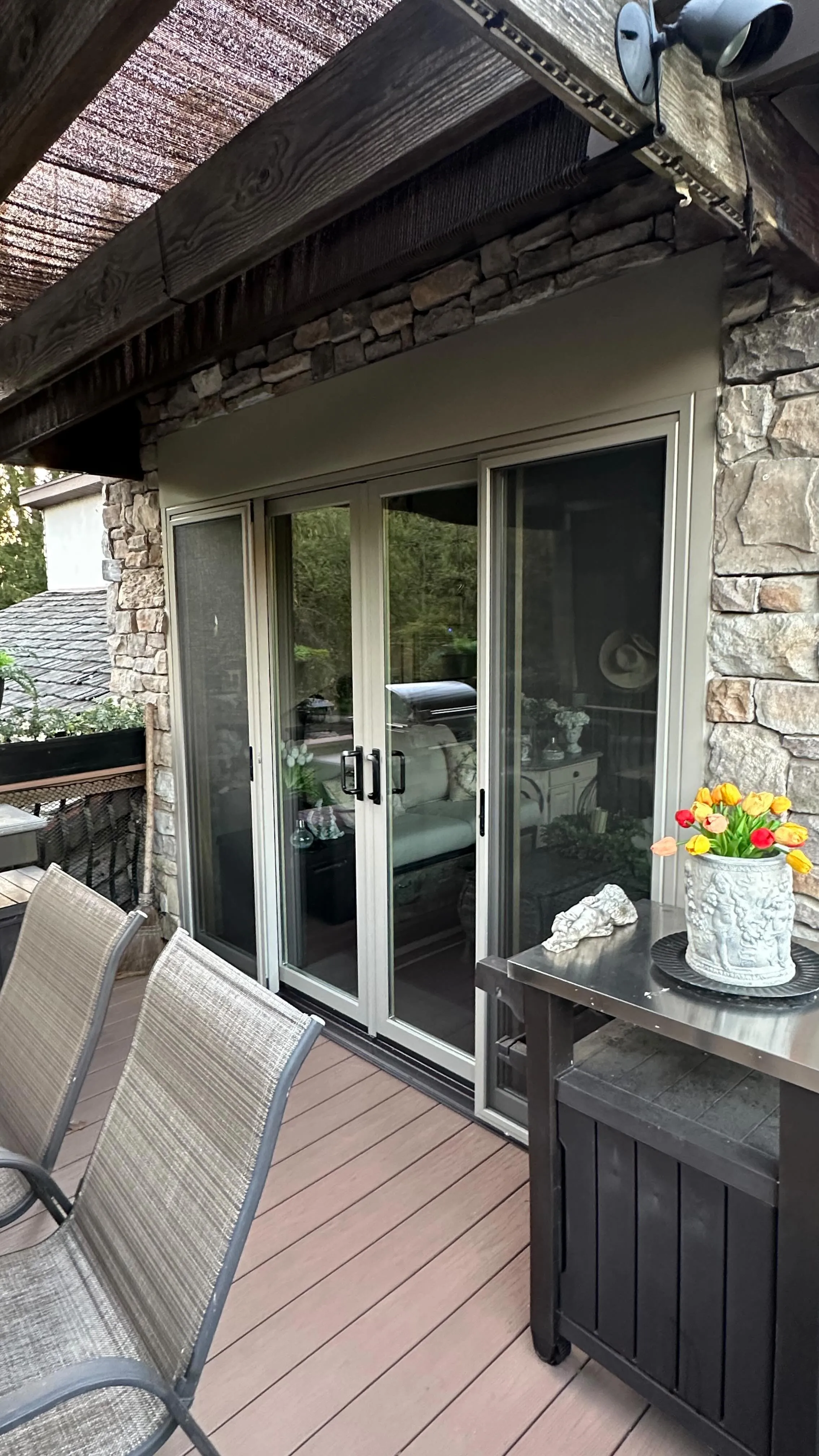 Sliding patio door: Stone wall, opening onto the deck. Installed by HomeTrust Windows & Doors.
