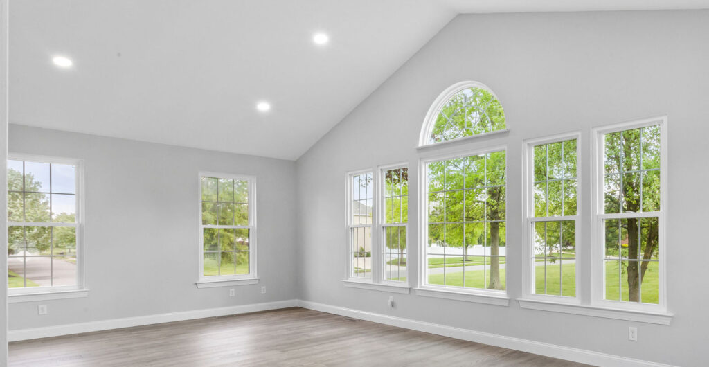 a room with a wood floor and windows